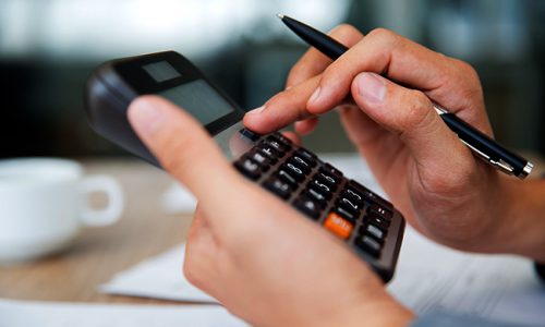 Close-up of male hands using calculator. Unrecognizable accountant holding pen when pushing button on calculator. Finance concept