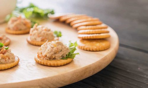 tuna spread with cracker on wood board