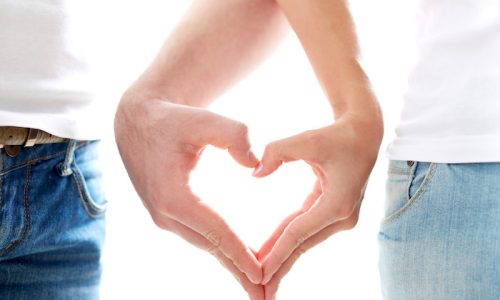 Conceptual image of female and male hands making up heart shape