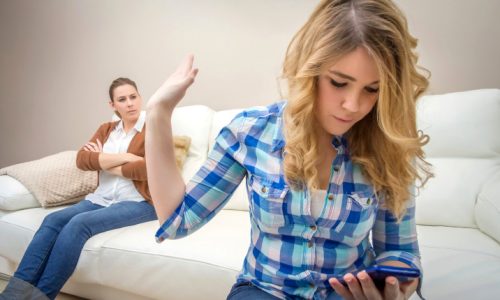 Daughter looking a phone and ignoring her mother