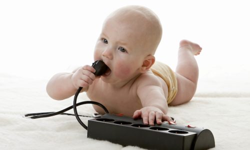 Sweet small baby with electric plug on a white background.