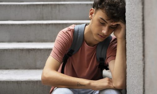 SolidãoAdolescente front-view-sad-boy-sitting-stairs