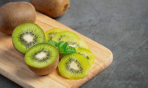 Fresh kiwi, cut into half, put on wooden cutting board